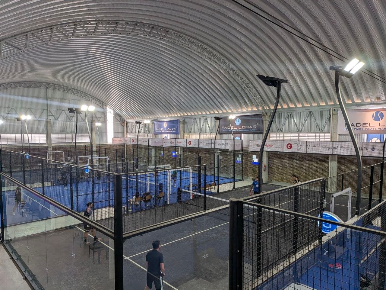 Cancha panorámica de pádel con cristal y buena iluminación en Padel Lomas